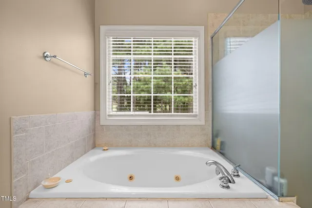 a white bath tub sitting in a bathroom next to a window
