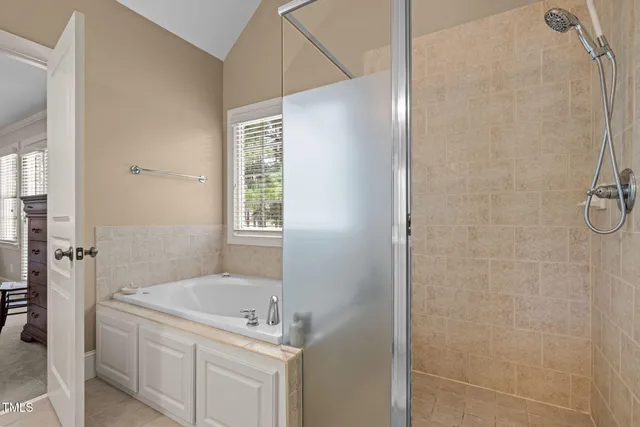 a bedroom with a bed a table chair and a chandelier