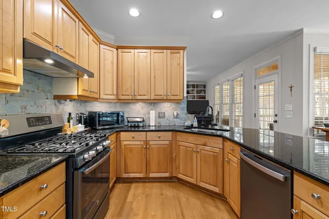 a kitchen with a sink a counter top space stainless steel appliances and cabinets