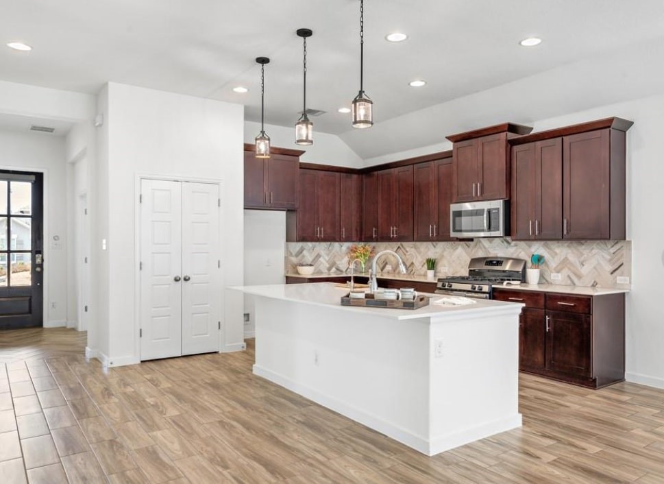 121 San Domenico Cove Georgetown, TX 78628 - Photo 5 of 24 a kitchen with stainless steel appliances granite countertop a sink a stove and a refrigerator