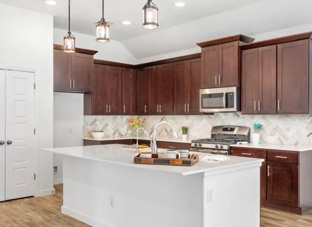 a kitchen with stainless steel appliances granite countertop a sink a stove and a refrigerator