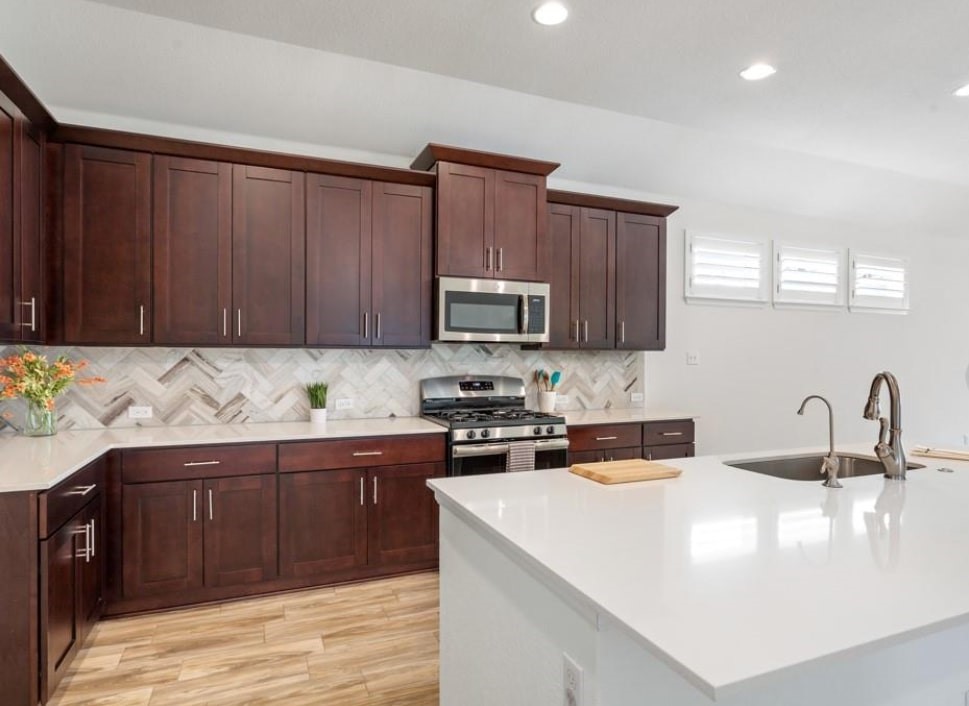 121 San Domenico Cove Georgetown, TX 78628 - Photo 7 of 24 a kitchen with stainless steel appliances granite countertop a sink stove and microwave