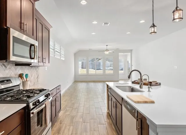 a kitchen with stainless steel appliances granite countertop a sink and stove