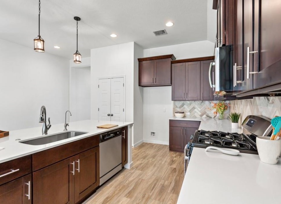 121 San Domenico Cove Georgetown, TX 78628 - Photo 10 of 24 a kitchen with stainless steel appliances a sink stove and wooden cabinets