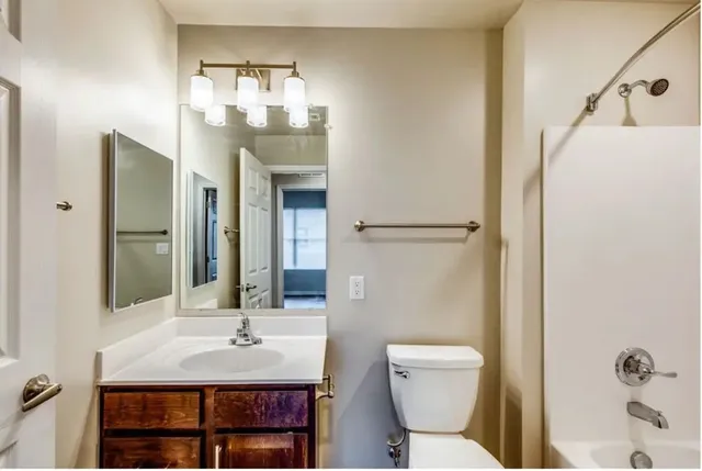 a bathroom with a sink and mirror with toilet
