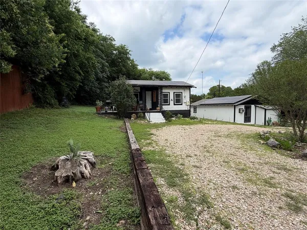 a backyard of a house with table and chairs