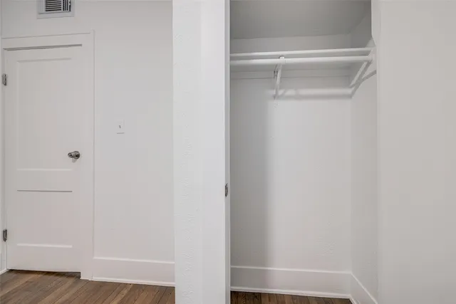 a view of a white house with a large trees