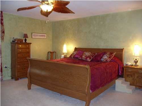 199 Country Club Road Shalimar, FL 32579 - Photo 16 of 21 a bed sitting in a bedroom next to a lamp