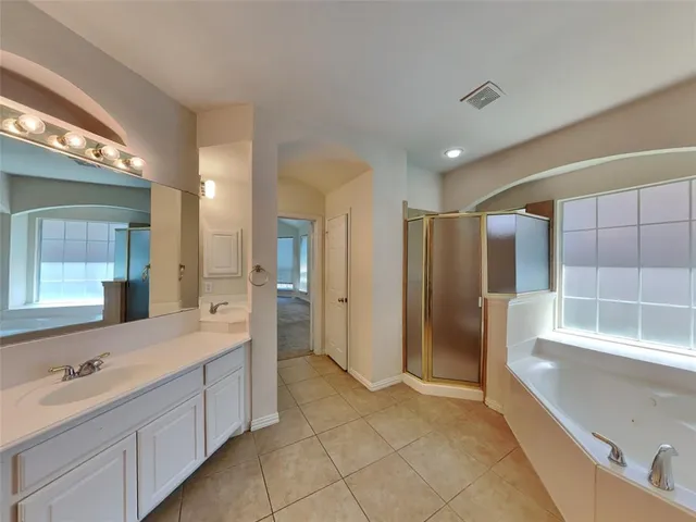 a bathroom with a double vanity sink mirror and shower