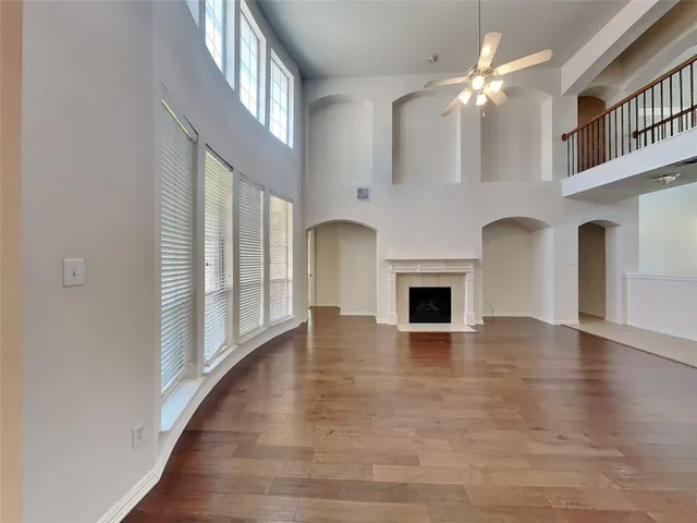 an empty room with windows and fireplace