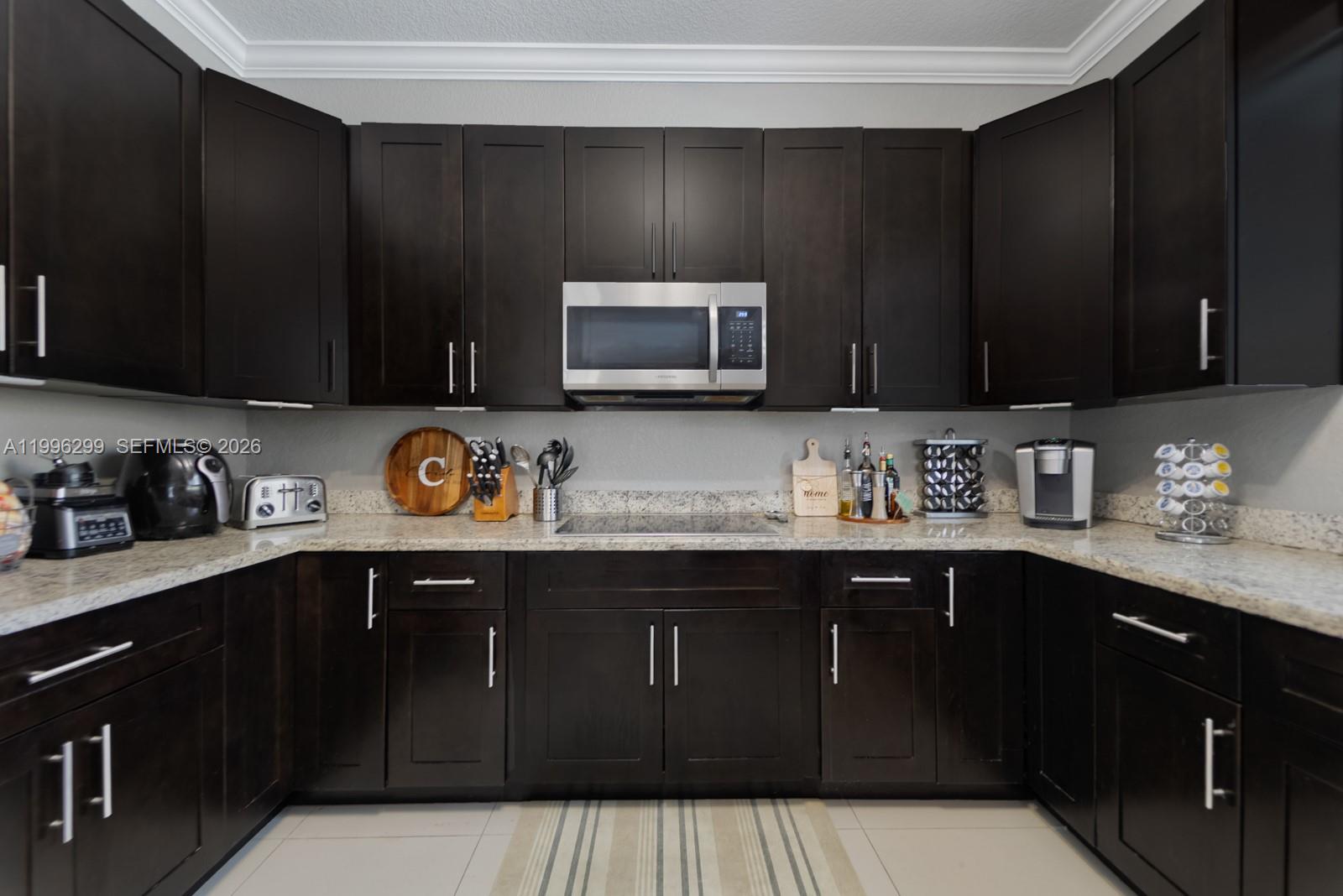 19781 Southwest 84th Court Cutler Bay, FL 33189 - Photo 13 of 53 a kitchen with granite countertop a sink dishwasher stove and cabinets with wooden floor