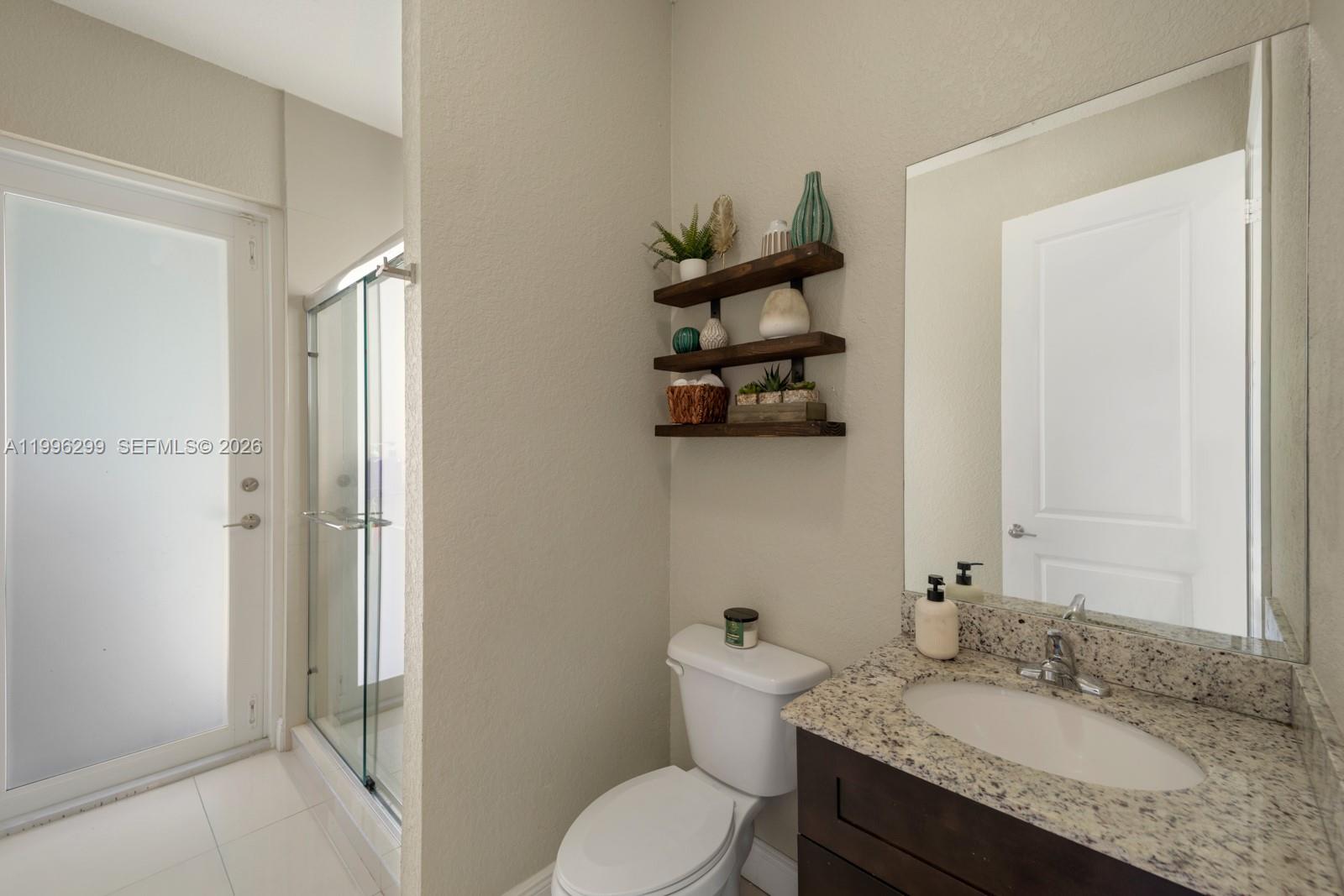 19781 Southwest 84th Court Cutler Bay, FL 33189 - Photo 19 of 53 a bathroom with a granite countertop sink toilet and shower