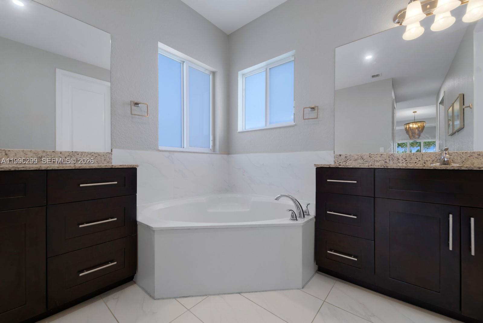 19781 Southwest 84th Court Cutler Bay, FL 33189 - Photo 29 of 53 a bathroom with a tub a sink and mirror