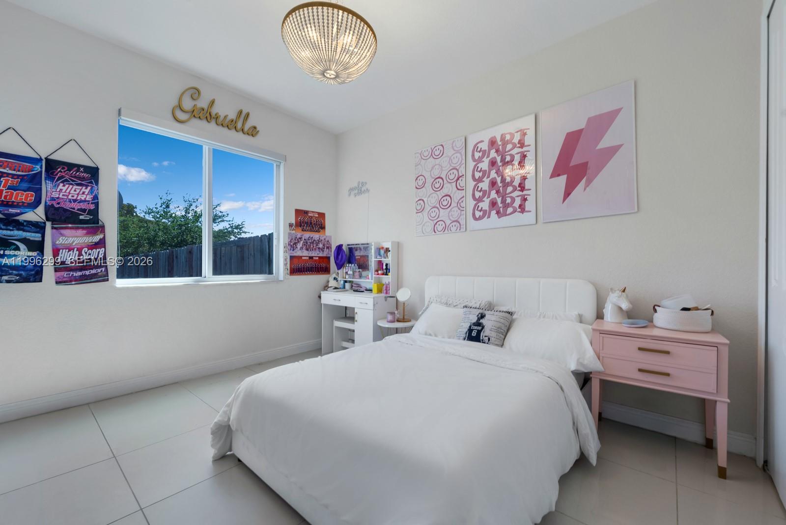 19781 Southwest 84th Court Cutler Bay, FL 33189 - Photo 30 of 53 a bedroom with a bed and a chandelier