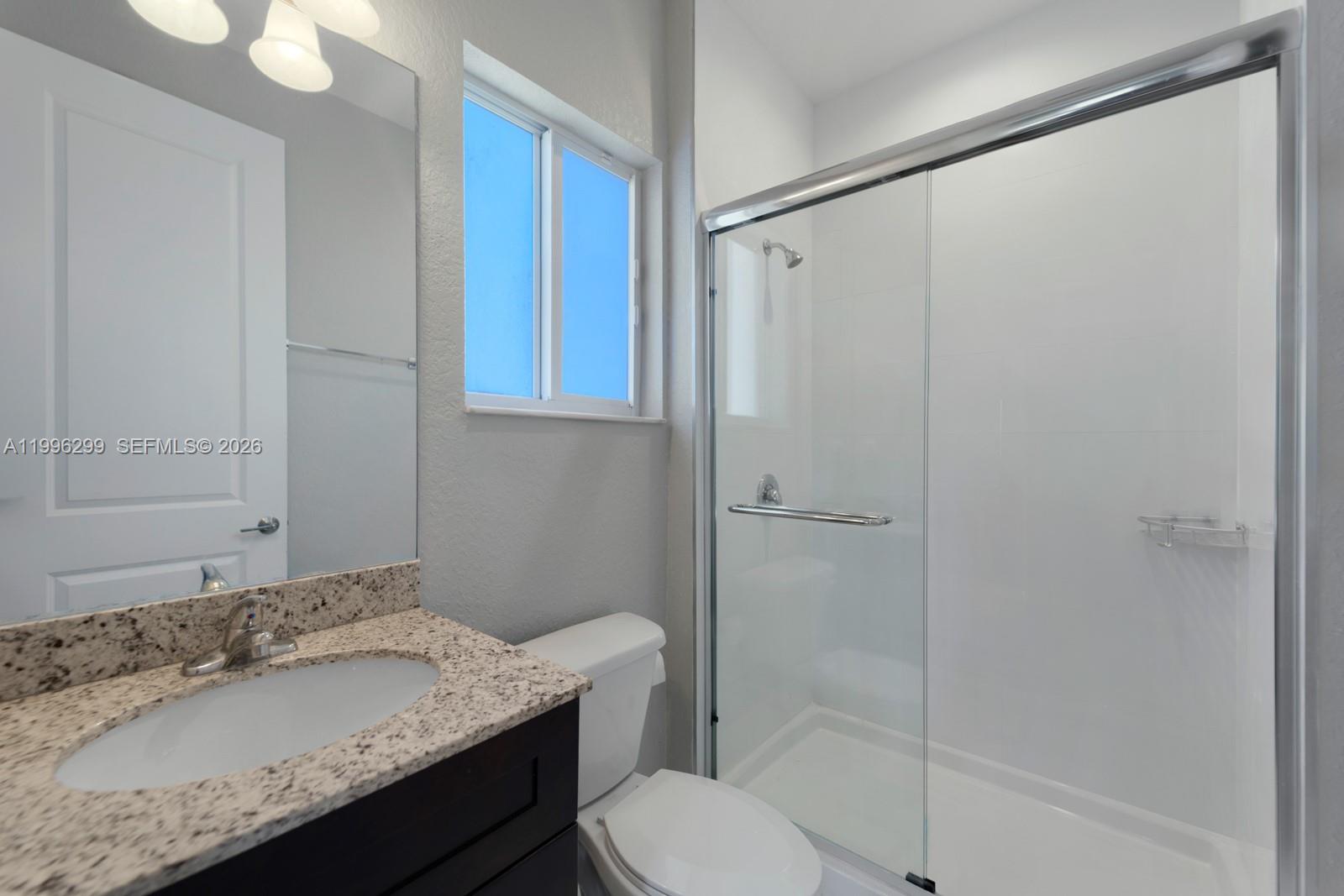 19781 Southwest 84th Court Cutler Bay, FL 33189 - Photo 36 of 53 a bathroom with a granite countertop sink toilet and shower