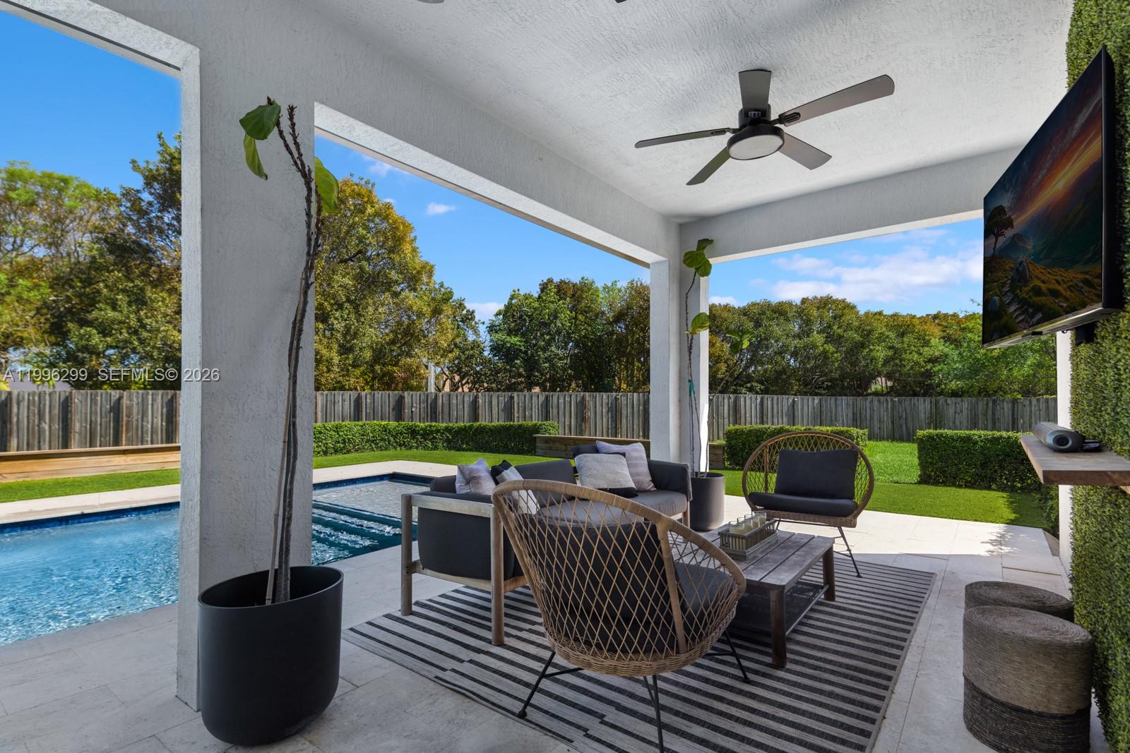 19781 Southwest 84th Court Cutler Bay, FL 33189 - Photo 43 of 53 a view of a patio with couches potted plants and a floor to ceiling window