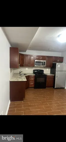 a view of kitchen with stainless steel appliances wooden floor