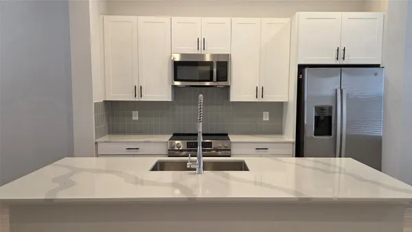 a kitchen with a refrigerator and a stove
