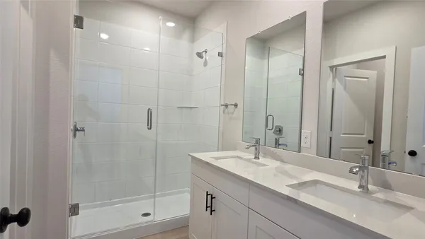 a bathroom with a granite countertop sink a mirror and a shower
