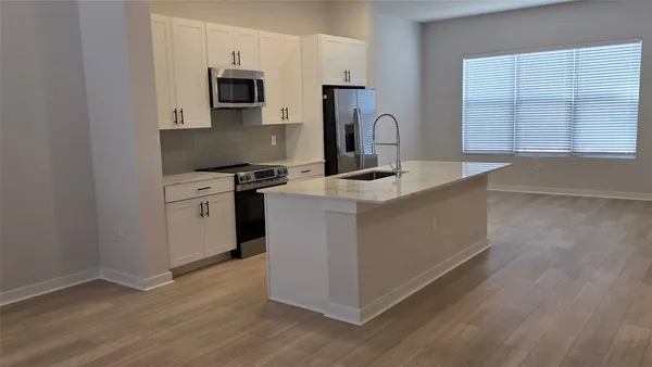 a kitchen with stainless steel appliances granite countertop a stove a sink and a microwave