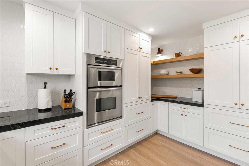 24701 Nympha Drive Mission Viejo, CA 92691 - Photo 22 of 75 a kitchen with granite countertop white cabinets and white appliances