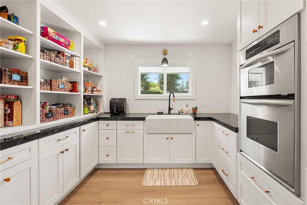 24701 Nympha Drive Mission Viejo, CA 92691 - Photo 23 of 75 a kitchen with white cabinets a sink and dishwasher with wooden floor