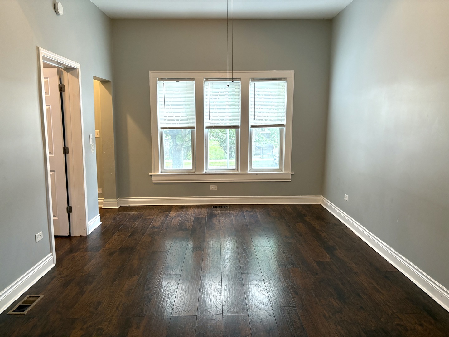 734 West 48th Place Chicago, IL 60609 - Photo 4 of 33 an empty room with wooden floor and windows