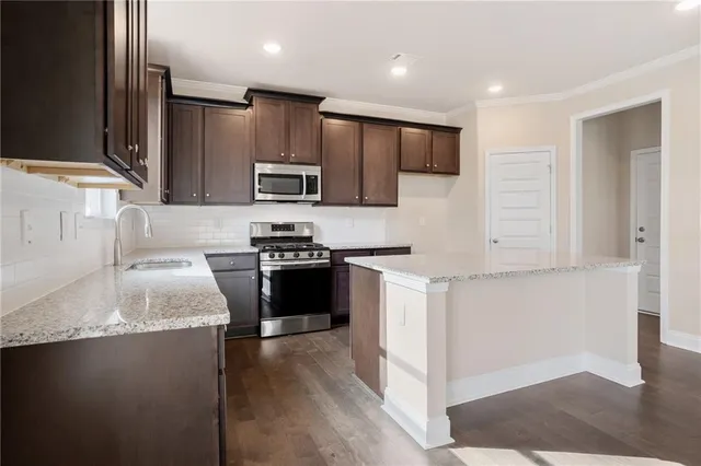 a kitchen with stainless steel appliances granite countertop a sink stove and refrigerator