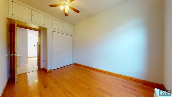 a view of empty room with wooden floor