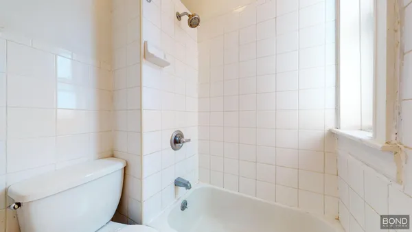 a bathroom with a toilet and bathtub
