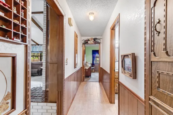 a view of a hallway with wooden floor and windows