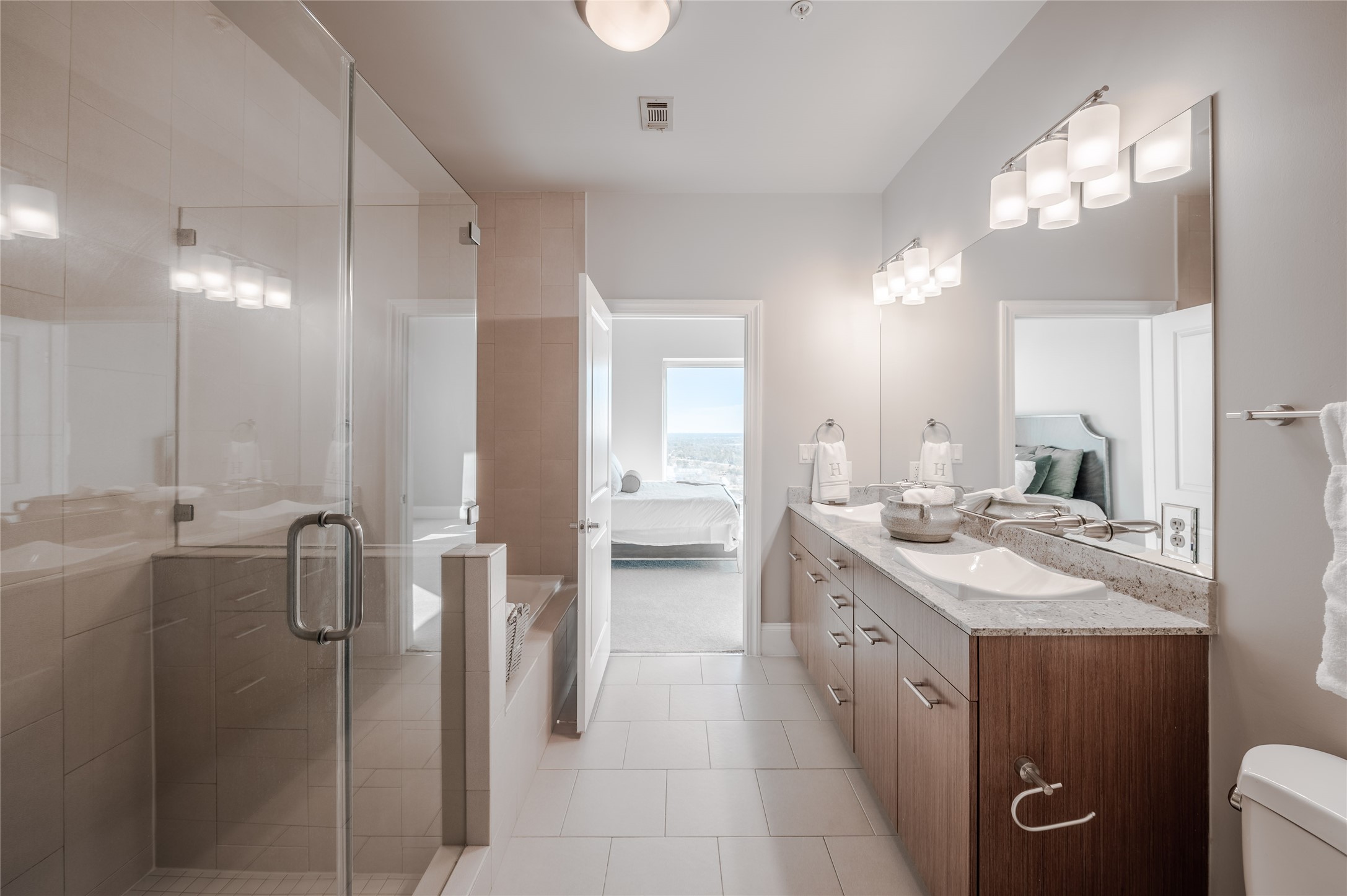 5927 Almeda Road, Unit 22803 Houston, TX 77004 - Photo 7 of 13 a bathroom with a double vanity sink a toilet a mirror and shower