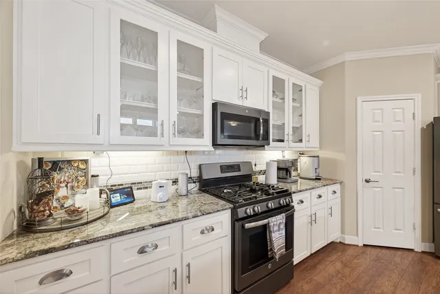 a kitchen with stainless steel appliances granite countertop a sink refrigerator and cabinets
