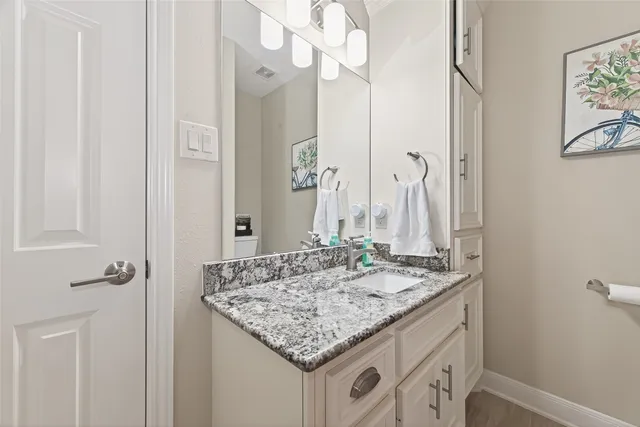 a bathroom with a granite countertop sink and a mirror