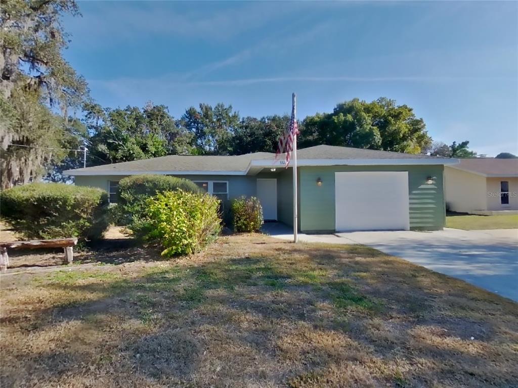 front view of a house with a yard and potted plants