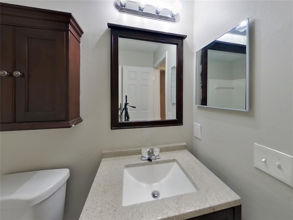 Undisclosed Address Spring Hill, FL 34606 - Photo 14 of 16 a bathroom with a toilet sink and mirror