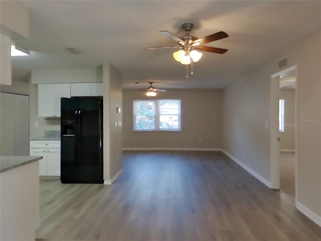 Undisclosed Address Spring Hill, FL 34606 - Photo 5 of 16 a view of an empty room with wooden floor and a window