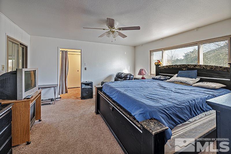 12005 Broken Hill Road Reno, NV 89511 - Photo 12 of 20 a spacious bedroom with a bed and a flat screen tv