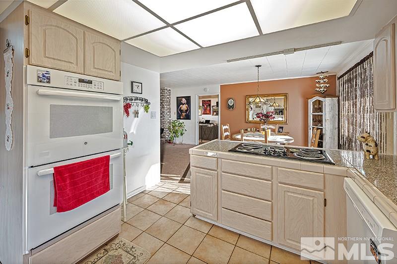 12005 Broken Hill Road Reno, NV 89511 - Photo 9 of 20 a kitchen with stainless steel appliances granite countertop a refrigerator a stove and a sink with wooden cabinets
