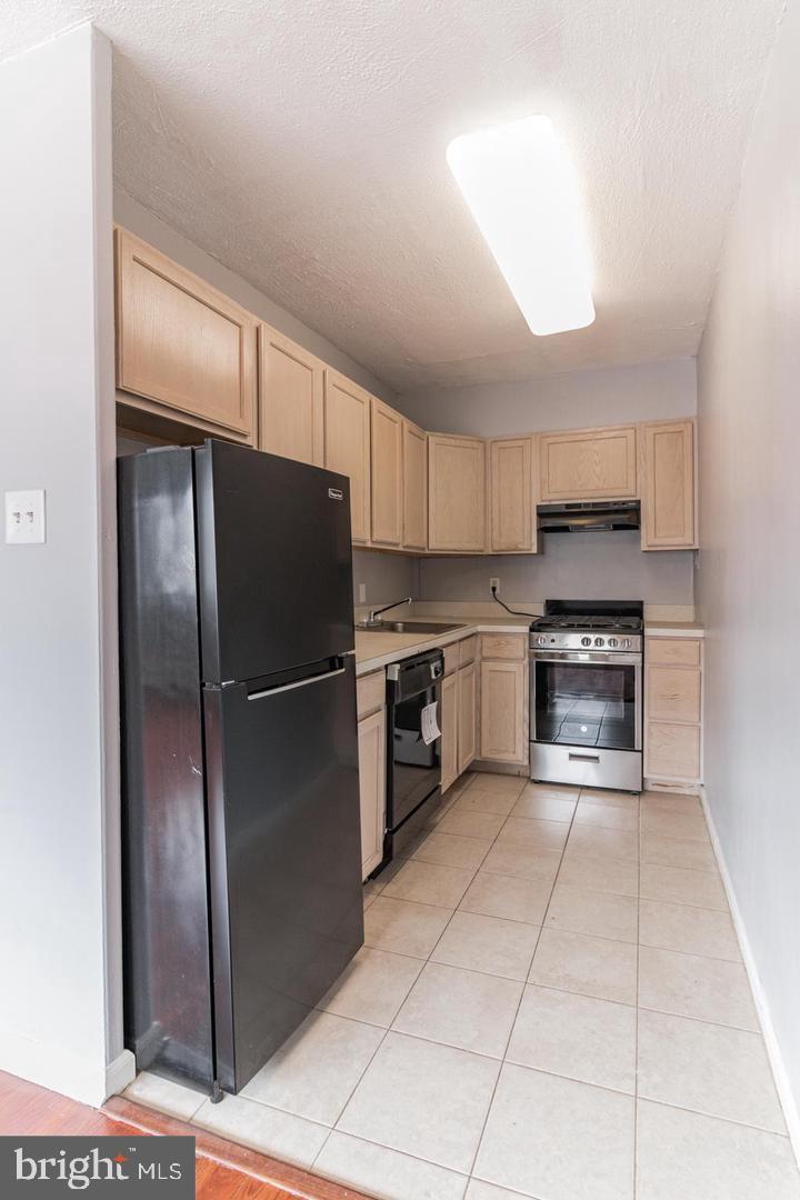 2101-17 Chestnut Street, Unit 1608 Philadelphia, PA 19103 - Photo 12 of 28 a kitchen with granite countertop a refrigerator and a stove top oven