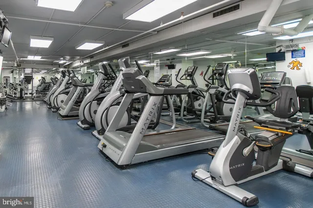 a living room with couches a dining table and chairs with white walls