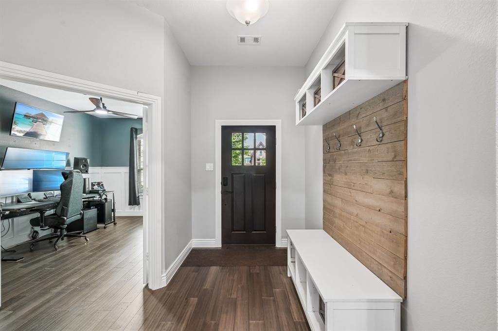 1805 Huntsman Way Forney, TX 75126 - Photo 2 of 34 Entryway featuring a built-in hall tree with a wood-finish plank accent wall, white storage bench, and overhead shelving