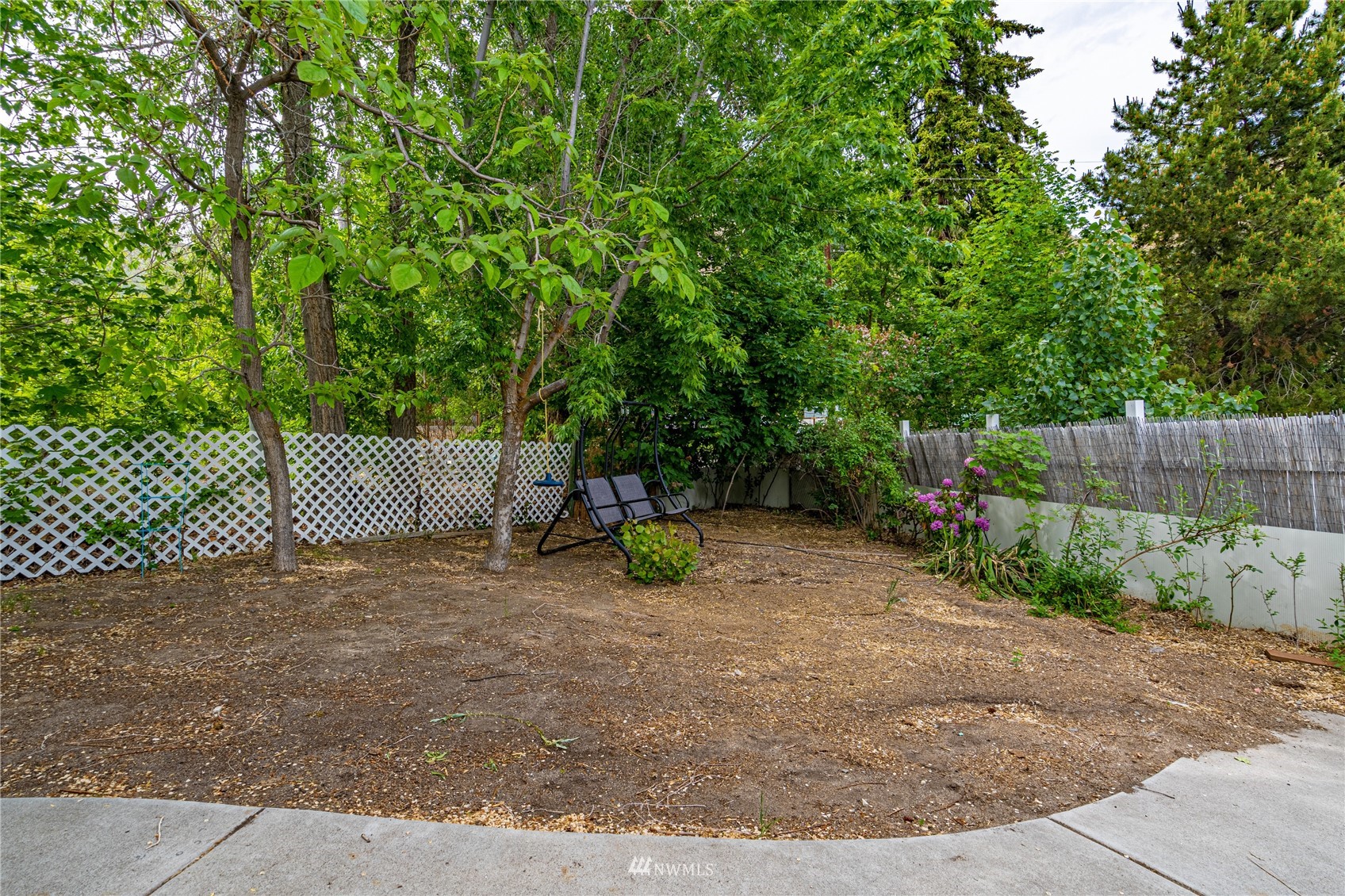 35 Apple Acres Road, Unit 112 Chelan, WA 98816 - Photo 33 of 35 a view of a park with a bench and trees with wooden fence