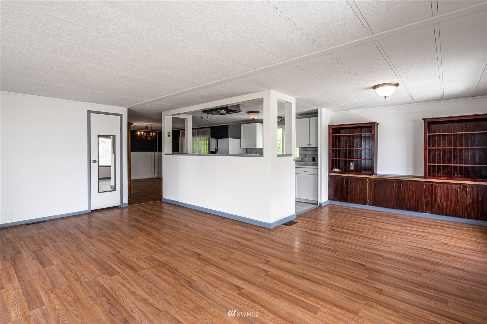 35 Apple Acres Road, Unit 112 Chelan, WA 98816 - Photo 4 of 35 a view of an empty room with wooden floor and a kitchen