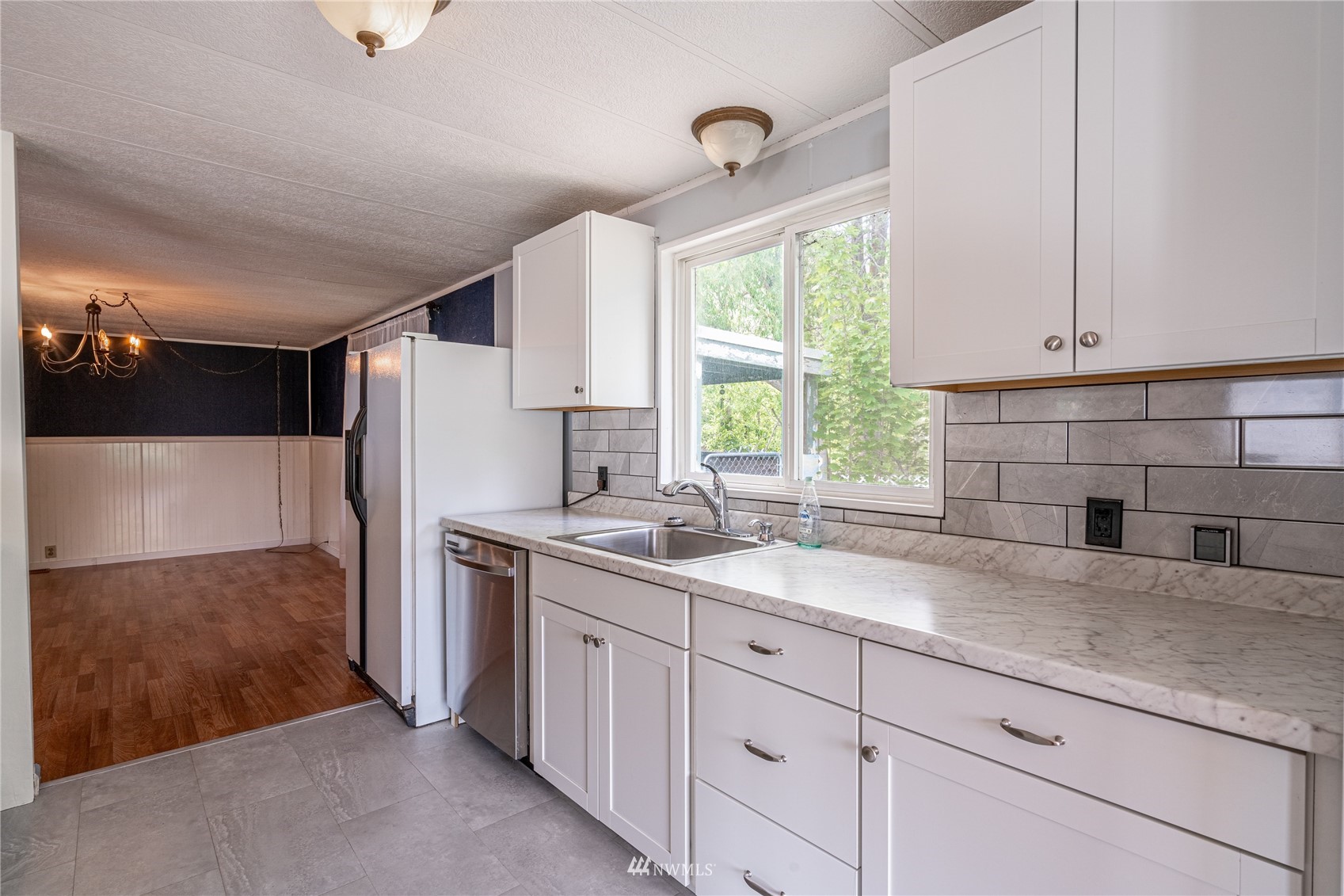 35 Apple Acres Road, Unit 112 Chelan, WA 98816 - Photo 7 of 35 a kitchen with a sink cabinets stainless steel appliances and a window