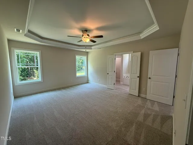 en empty room with windows and ceiling fan