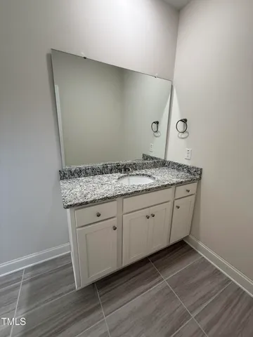 a utility room with granite countertop cabinets and sink