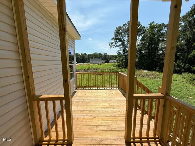 a view of a balcony with a floor to ceiling window stairs and wooden fence