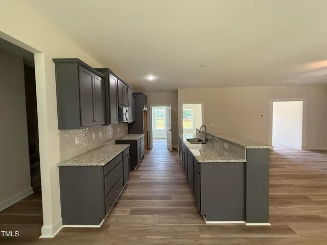 a kitchen with stainless steel appliances granite countertop a stove and a wooden floors