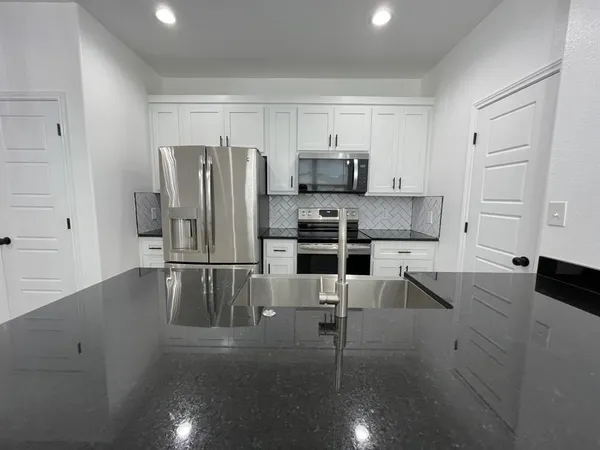 a kitchen with stainless steel appliances a refrigerator and microwave